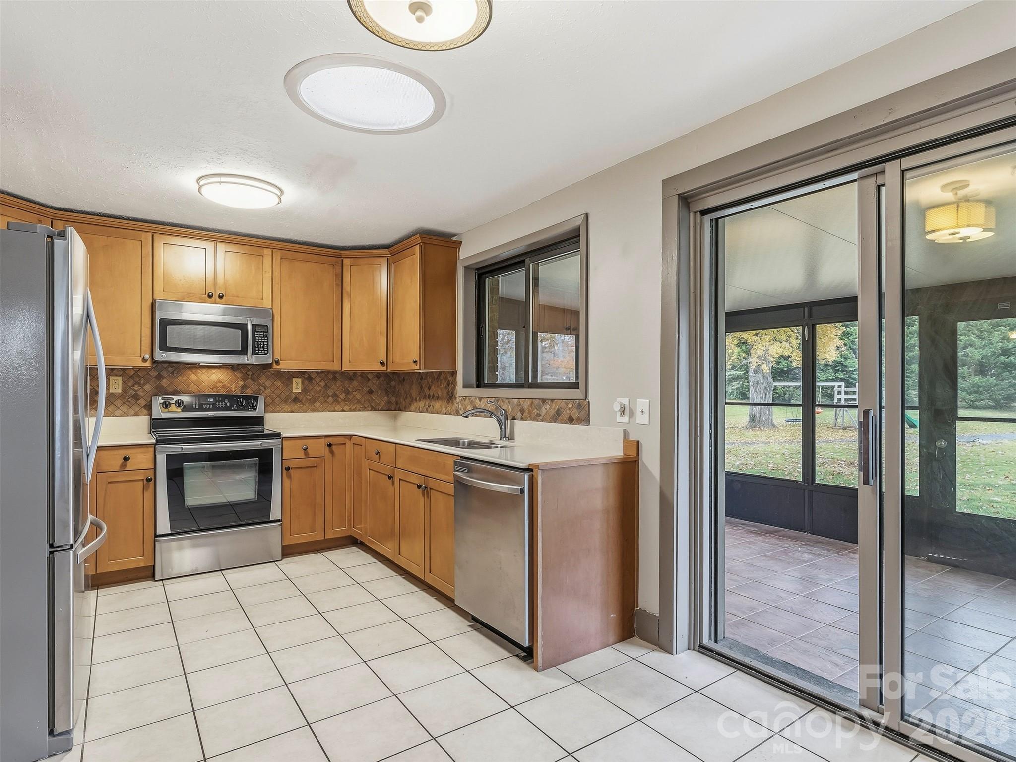 605 Dana Road Hendersonville, NC 28792 - Photo 15 of 38 a kitchen with stainless steel appliances granite countertop a stove top oven a sink dishwasher a refrigerator and a microwave