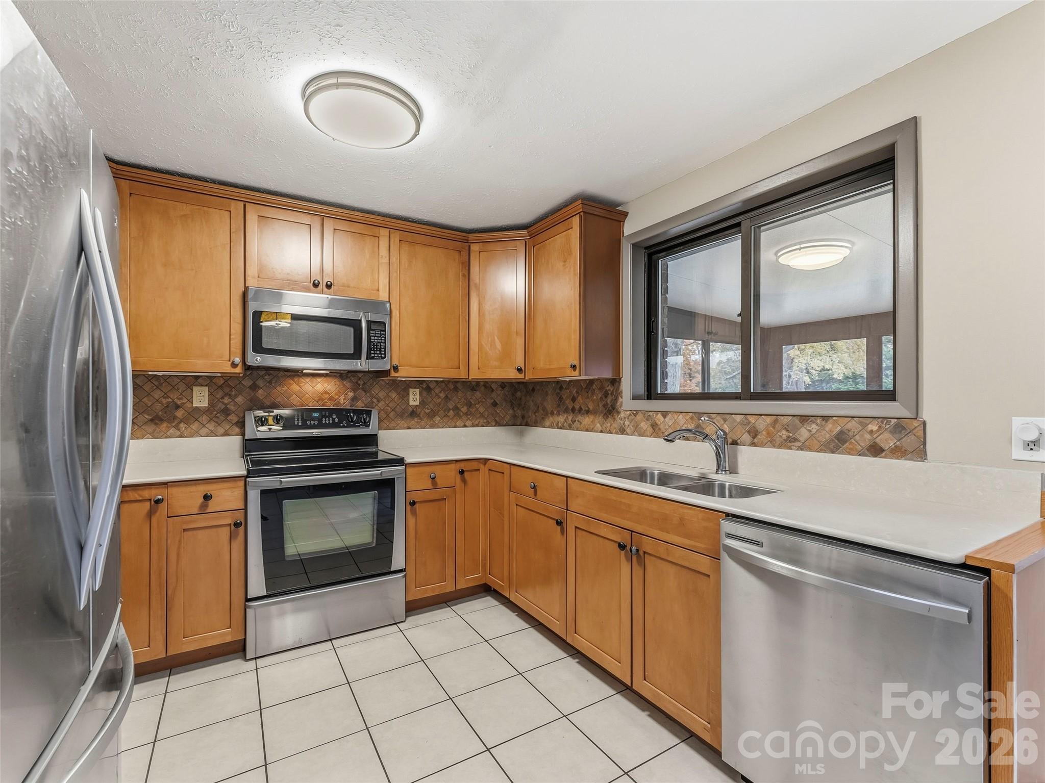 605 Dana Road Hendersonville, NC 28792 - Photo 17 of 38 a kitchen with stainless steel appliances granite countertop a sink and stove top oven