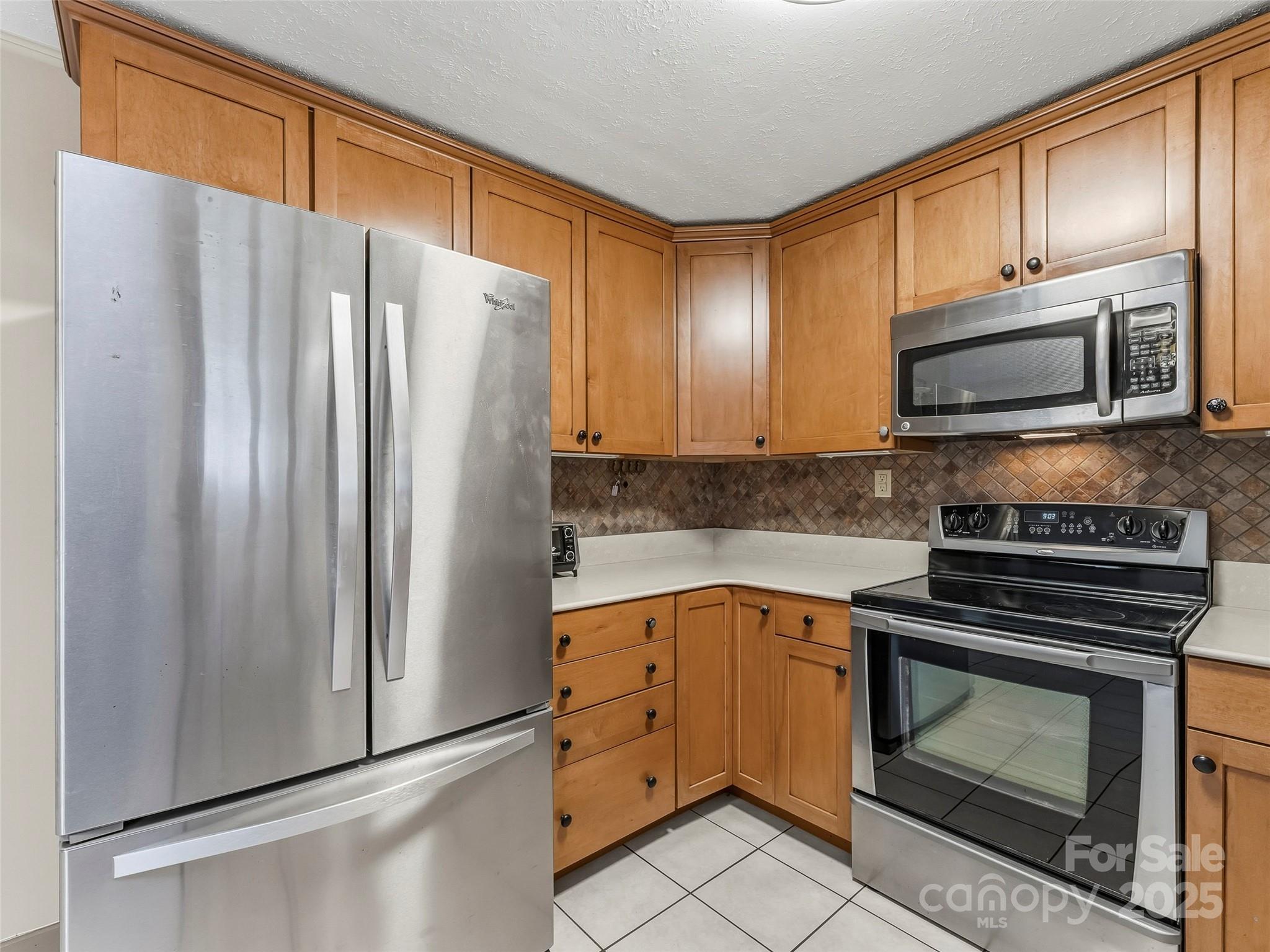 605 Dana Road Hendersonville, NC 28792 - Photo 18 of 38 a kitchen with granite countertop a refrigerator stove and microwave