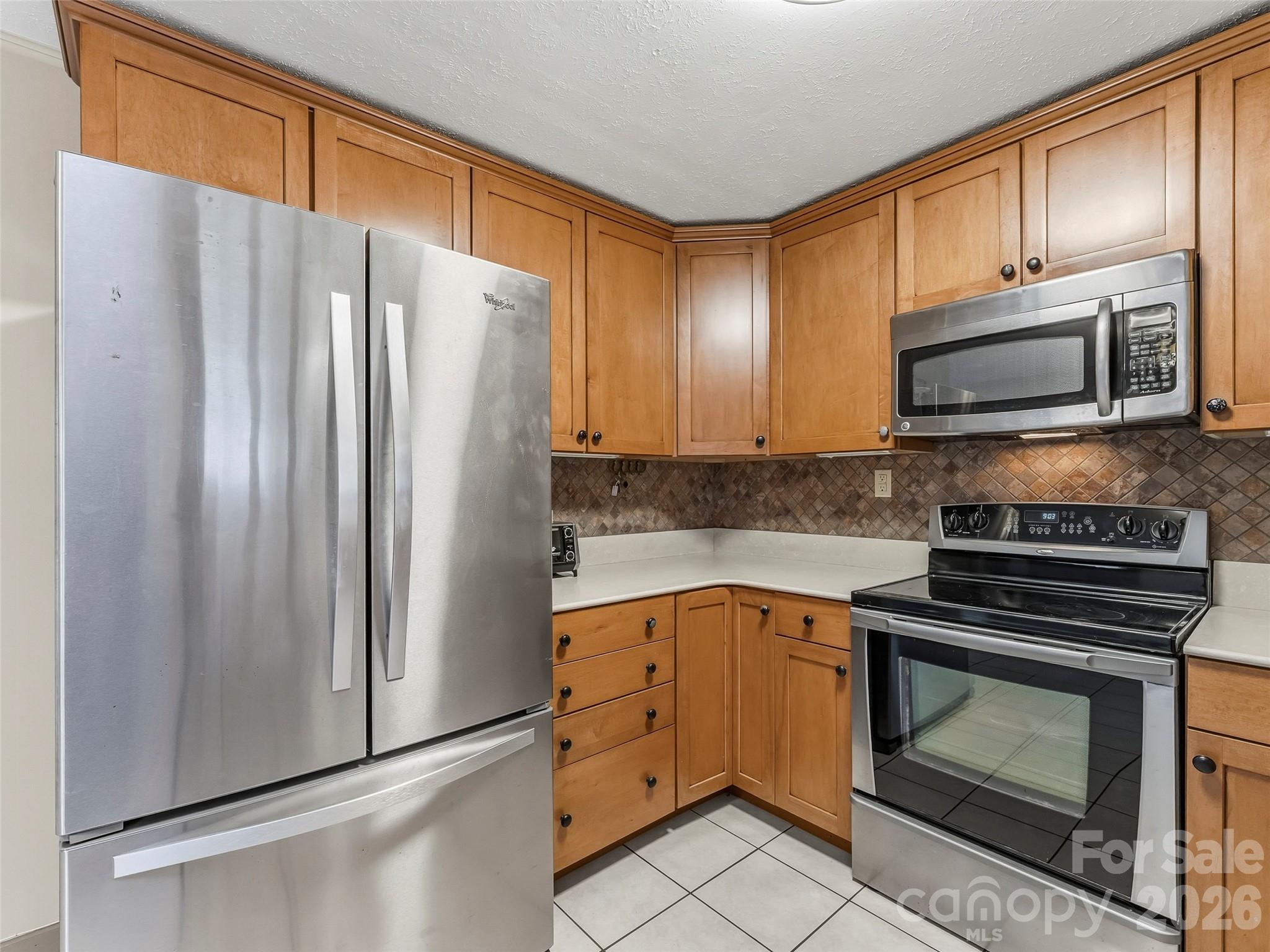 605 Dana Road Hendersonville, NC 28792 - Photo 19 of 38 a kitchen with granite countertop a refrigerator stove and microwave