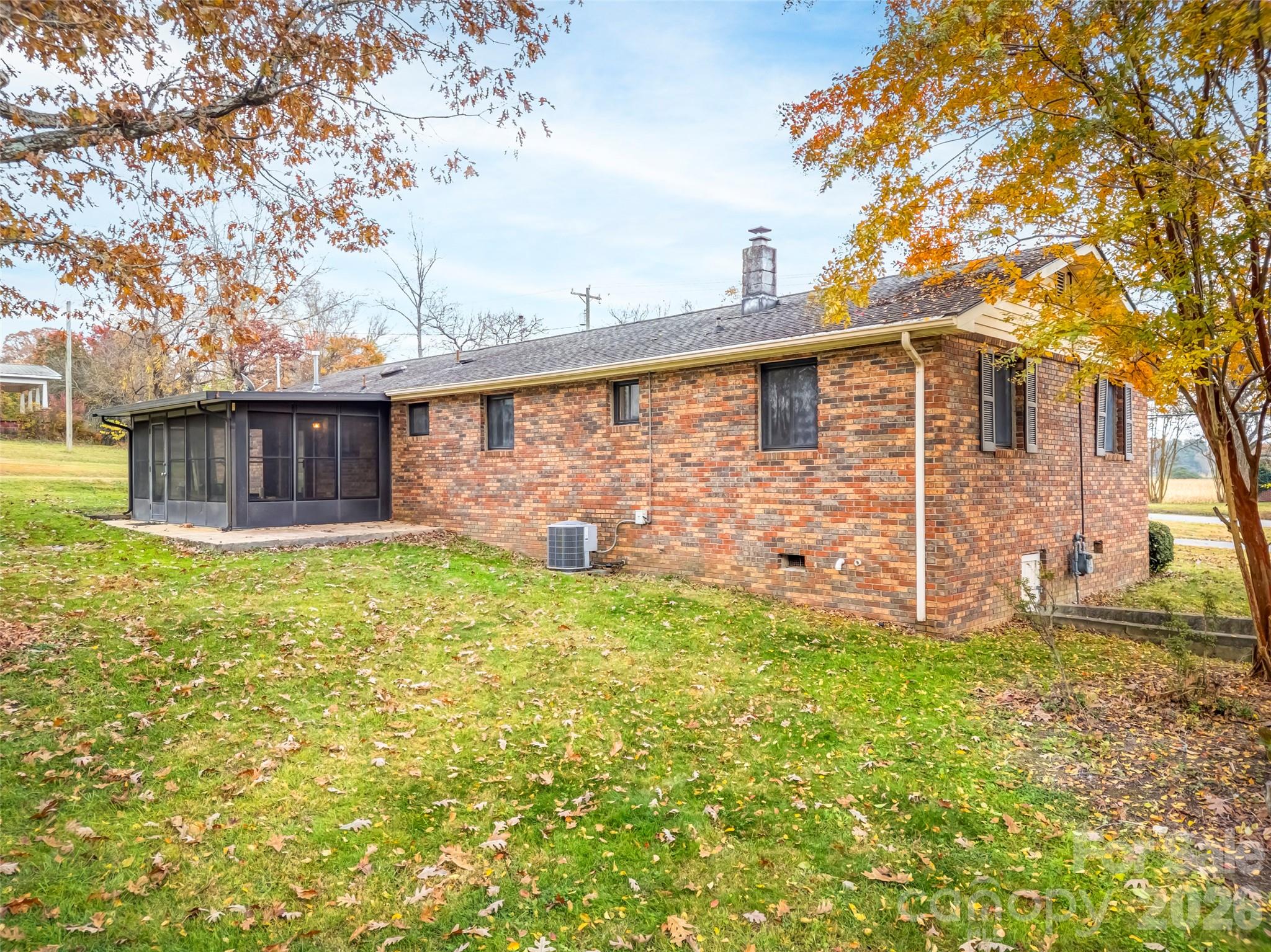 605 Dana Road Hendersonville, NC 28792 - Photo 9 of 38 a brick house with a large tree in front of it