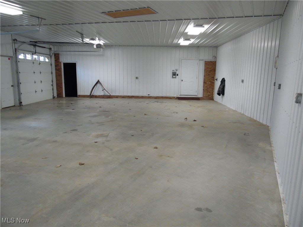 Garage featuring metal wall and a garage door opener