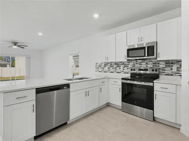 a kitchen with white cabinets and stainless steel appliances