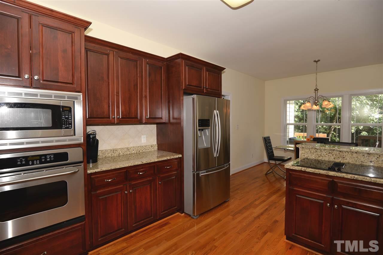 1021 Grissom Farm Road Garner, NC 27529 - Photo 11 of 25 a kitchen with granite countertop wooden cabinets and stainless steel appliances