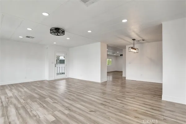 a view of empty room with wooden floor