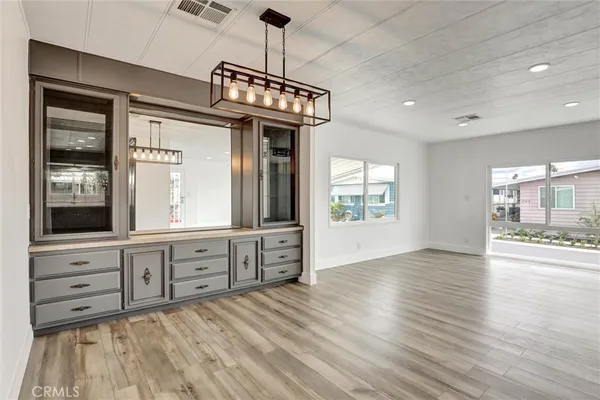 a kitchen with cabinets stainless steel appliances and wooden floor