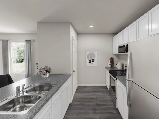 a kitchen with granite countertop a sink stove and refrigerator