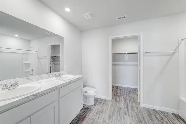 a bathroom with a sink a toilet and a large mirror