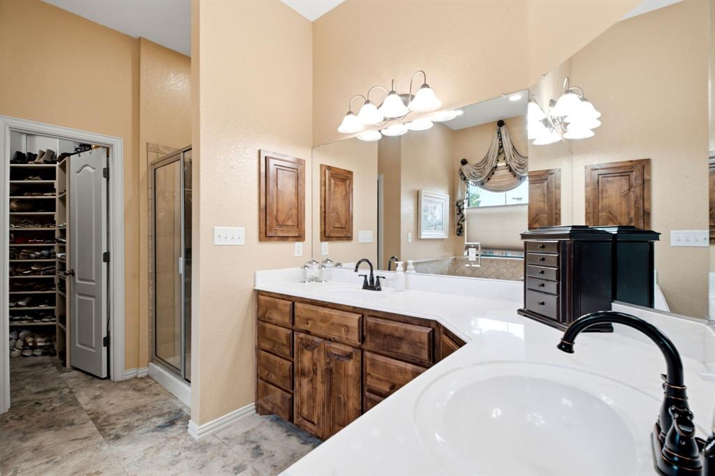 600 Aspen Street Pilot Point, TX 76258 - Photo 11 of 39 Bathroom featuring a double vanity with white countertops, dark wood-finish cabinetry, and contemporary dark bronze fixtures