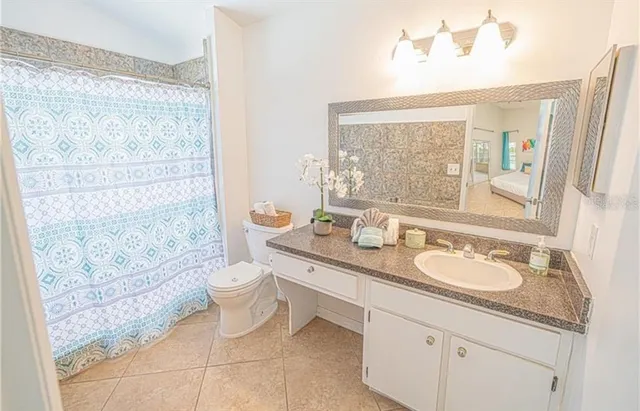 a bathroom with a granite countertop sink toilet a mirror and shower