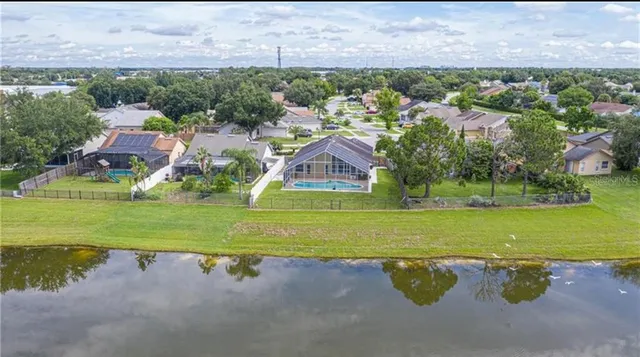 an aerial view of a house with a garden and lake view