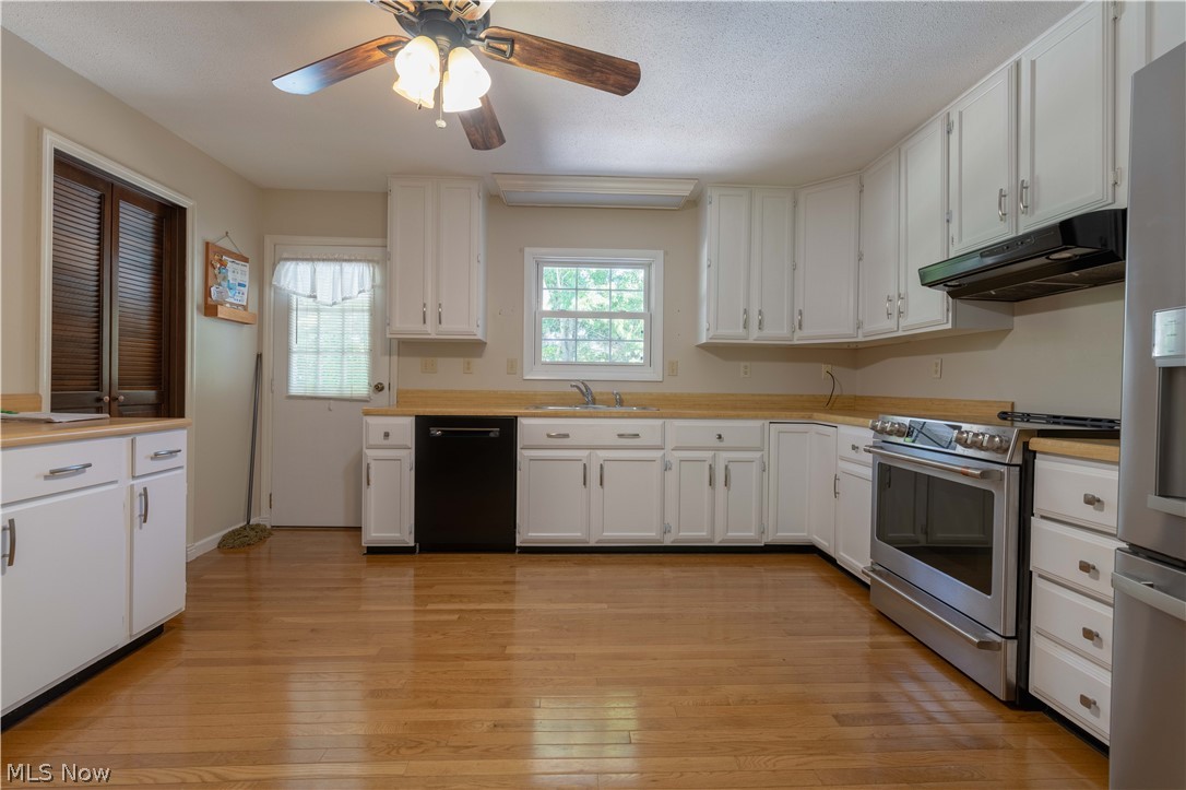 3963 Mark Road Cambridge, OH 43725 - Photo 10 of 50 Kitchen with ceiling fan, light hardwood / wood-style floors, dishwasher, electric range, and white cabinetry