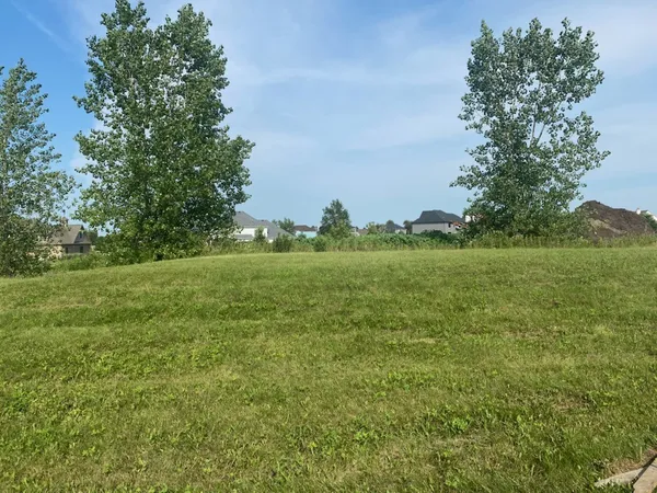 a yard with lots of green space and trees all around