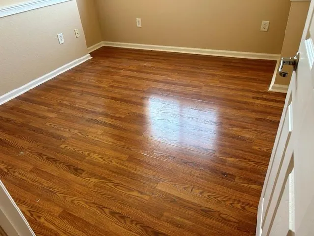 a view of an empty room with wooden floor