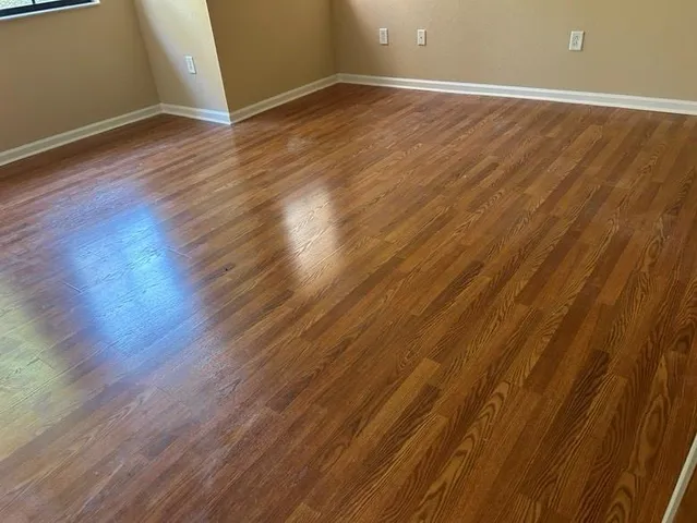 a view of an empty room with wooden floor