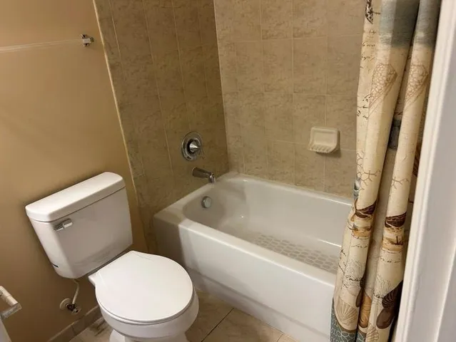 a white toilet sitting next to a bath tub