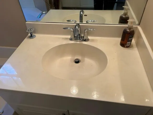 a bathroom with a tub sink and mirror