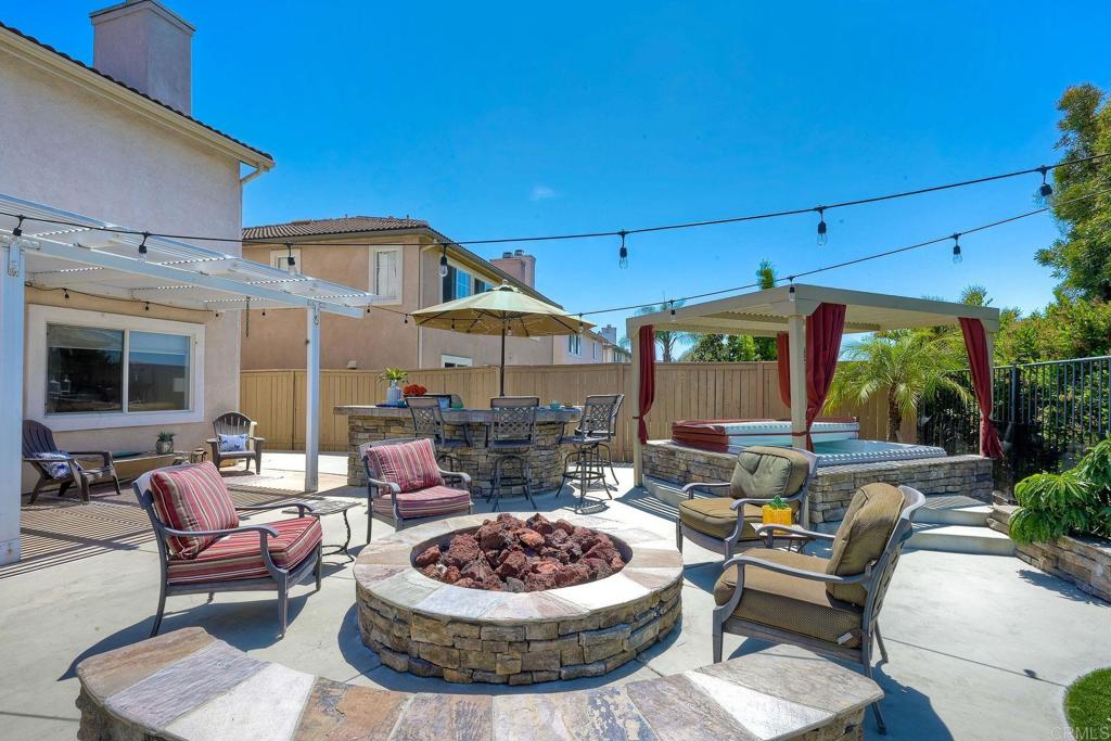 345 La Soledad Way Oceanside, CA 92057 - Photo 30 of 34 a patio with a table and chairs under an umbrella