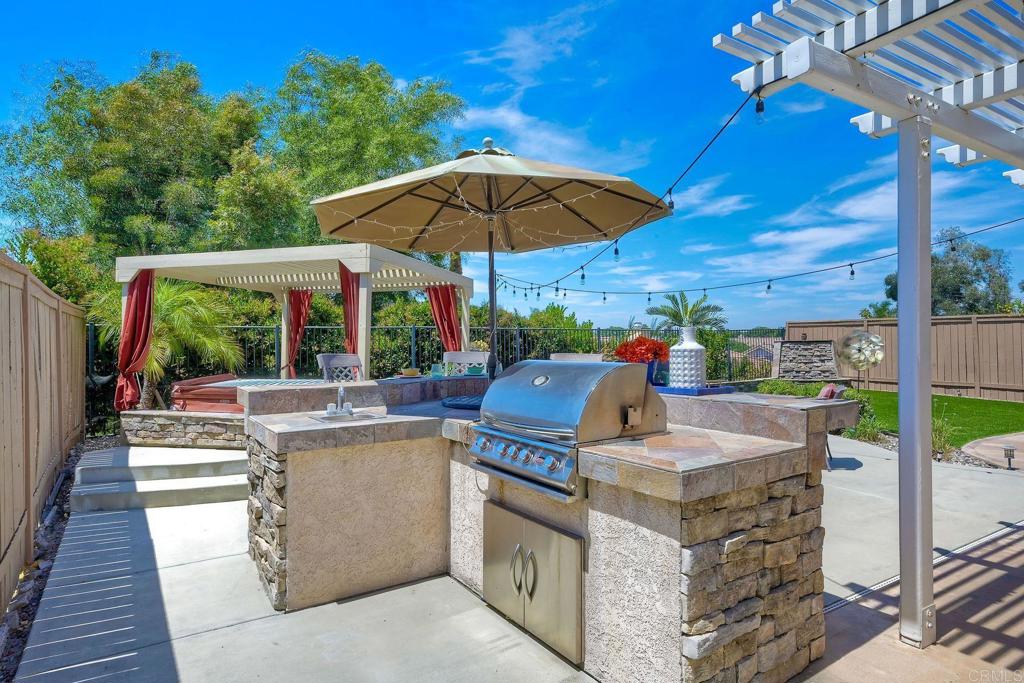 345 La Soledad Way Oceanside, CA 92057 - Photo 32 of 34 a view of a patio with table and chairs under an umbrella