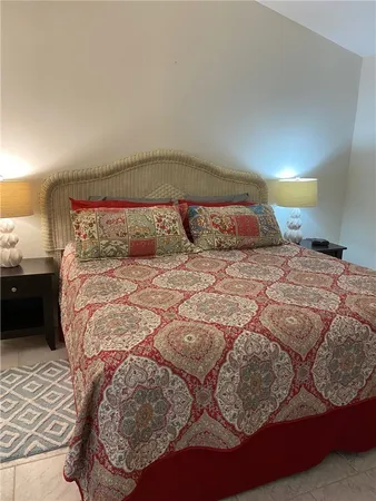 a bedroom with a large bed and a lamp