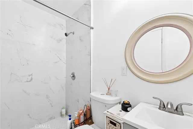 a bathroom with a sink a toilet and a mirror