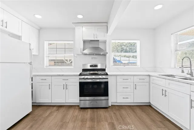 a kitchen with stainless steel appliances white cabinets and a refrigerator