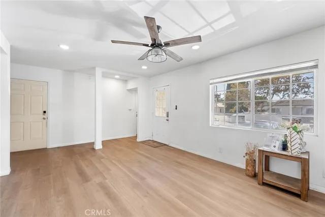 a view of an empty room with a window and wooden floor