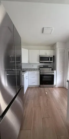 a large kitchen with cabinets and stainless steel appliances