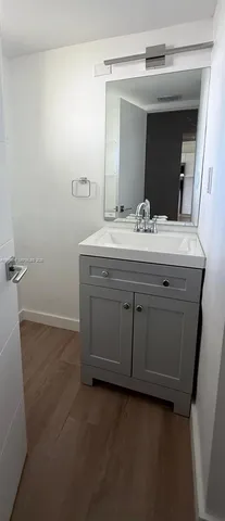 a bathroom with a granite countertop sink and mirror