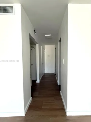 a view of a hallway with wooden floor