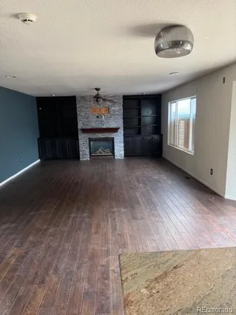 a kitchen with kitchen island granite countertop a stove top oven a sink dishwasher a dining table and chairs with wooden floor
