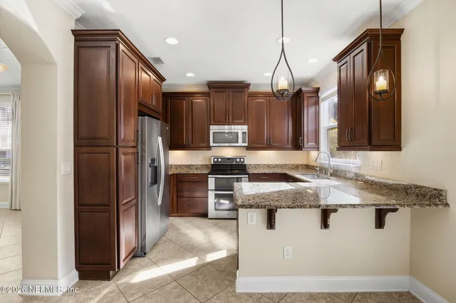 a kitchen with stainless steel appliances granite countertop a sink a stove a refrigerator and a oven