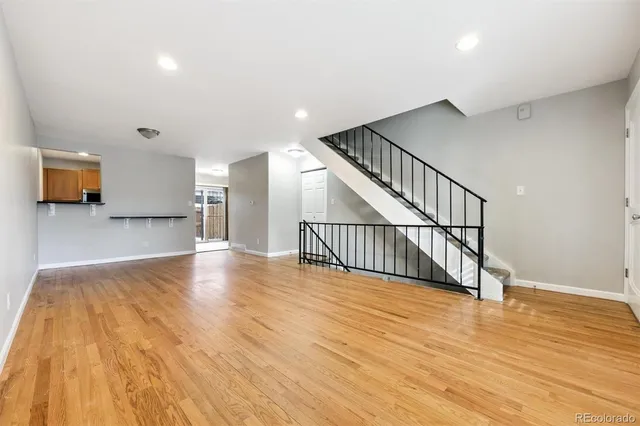 a view of a hallway with wooden floor and a chandelier