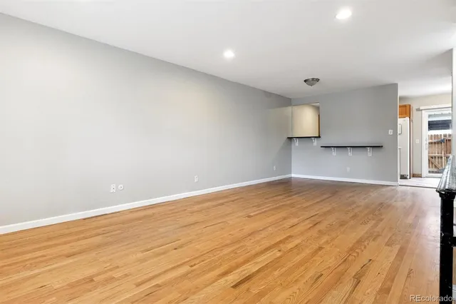a view of empty room with wooden floor and window