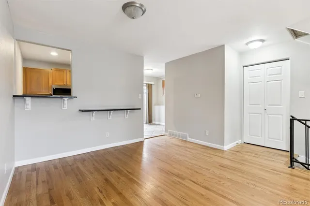 a view of empty room with wooden floor