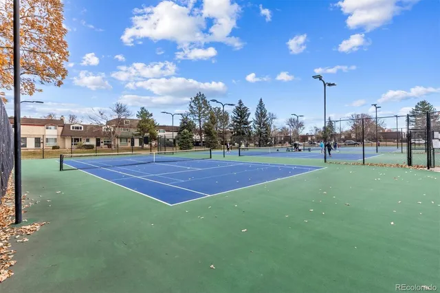 a lawn tennis court with view of trees in the background