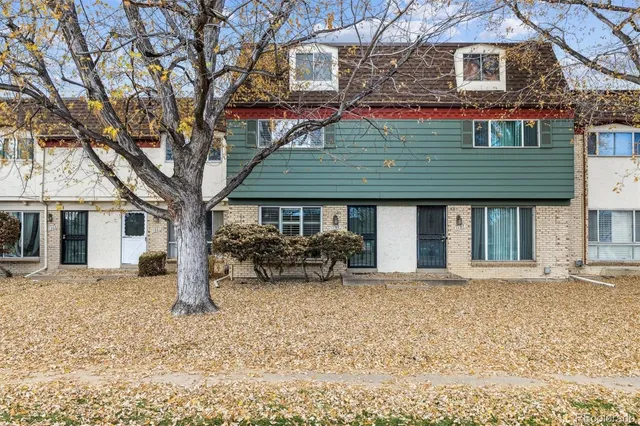 a front view of a house with a yard covered in snow