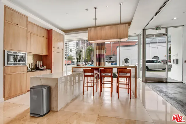 a kitchen with stainless steel appliances granite countertop a stove top oven a sink a dining table and chairs with wooden floor