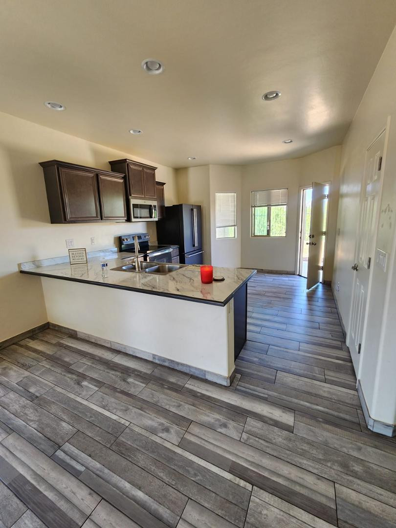 3641 Camino Del Rancho Douglas, AZ 85607 - Photo 2 of 20 a living room with kitchen view and a flat screen tv