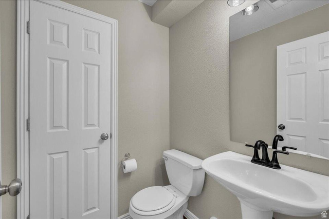 3155 South Hidden Dr Street, Unit 248 St. George, UT 84790 - Photo 9 of 24 Pedestal sink with a matte black faucet, wall-mounted mirror, and overhead vanity lighting