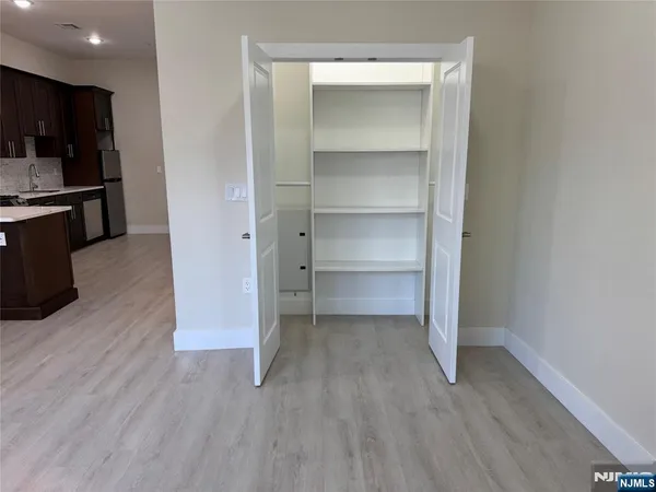 a view of a room with wooden floor and cabinets