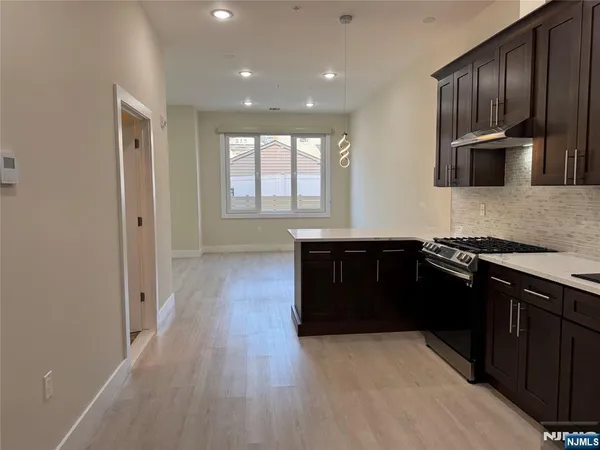 a kitchen with stainless steel appliances granite countertop a stove a sink and a refrigerator