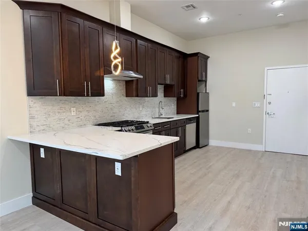 a kitchen with stainless steel appliances granite countertop a sink stove and refrigerator