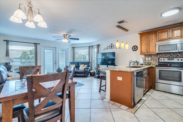 a kitchen with a stove a table and chairs in it