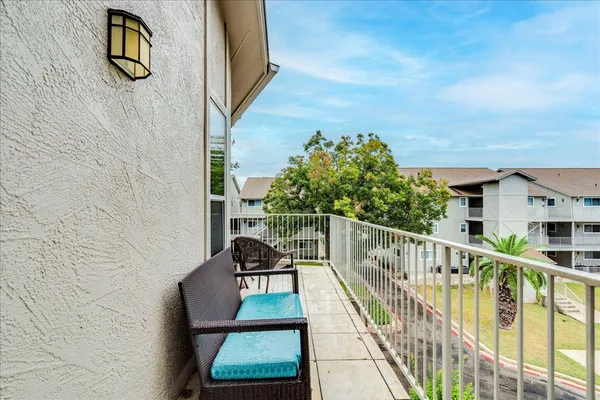 a balcony with table and chairs