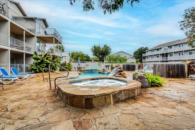 a swimming pool with outdoor seating and plants