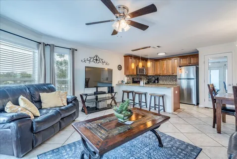 a living room with furniture kitchen view and a large window