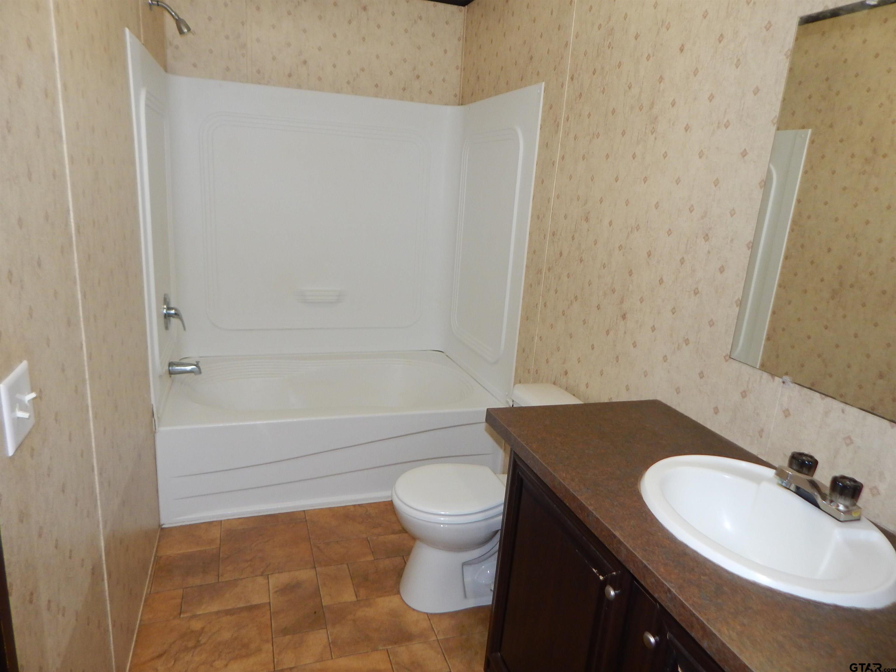 958 Boles Road Gilmer, TX 75645 - Photo 12 of 29 a bathroom with a sink and a mirror