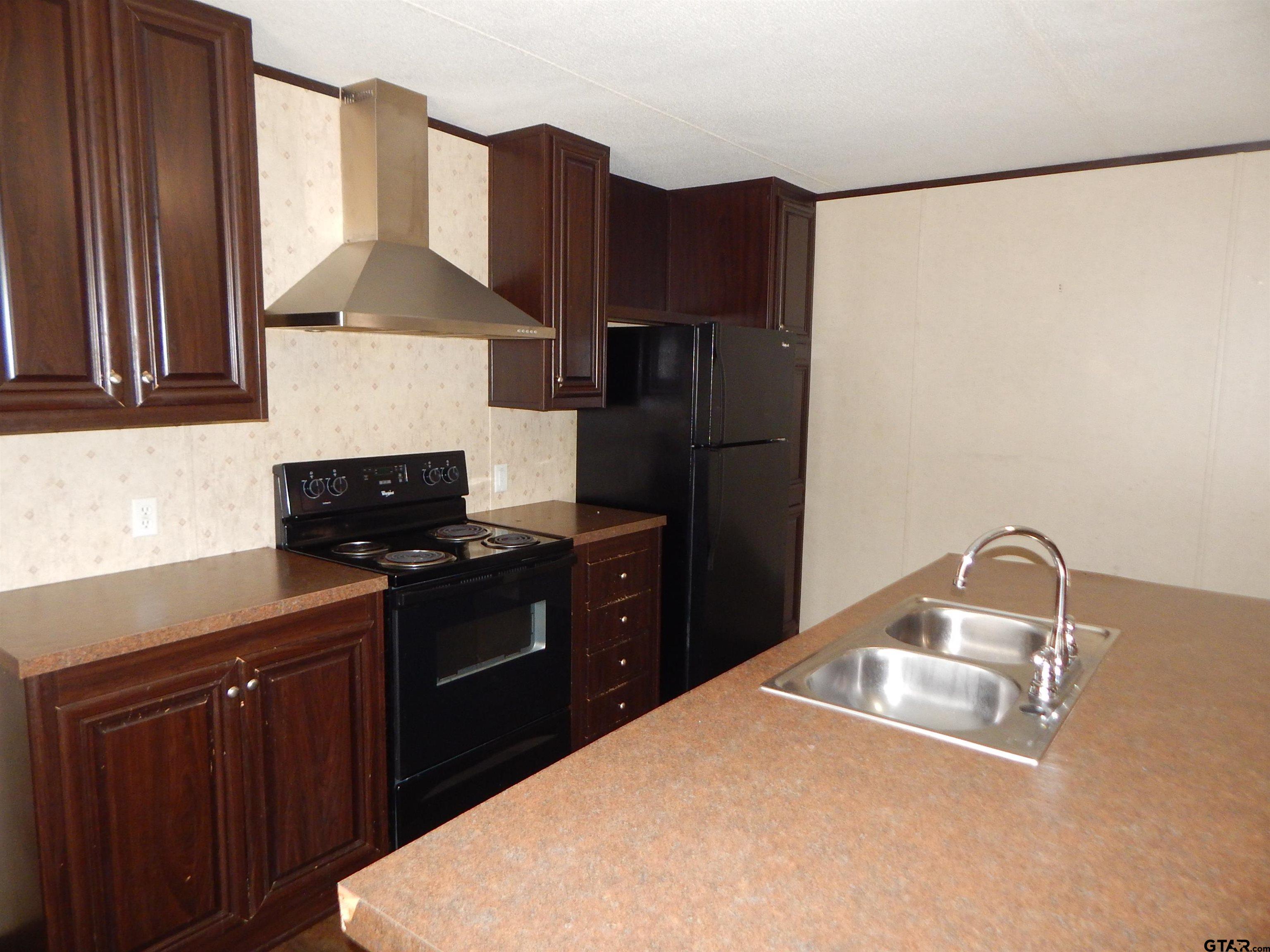 958 Boles Road Gilmer, TX 75645 - Photo 16 of 29 a kitchen with stainless steel appliances a refrigerator and a stove top oven