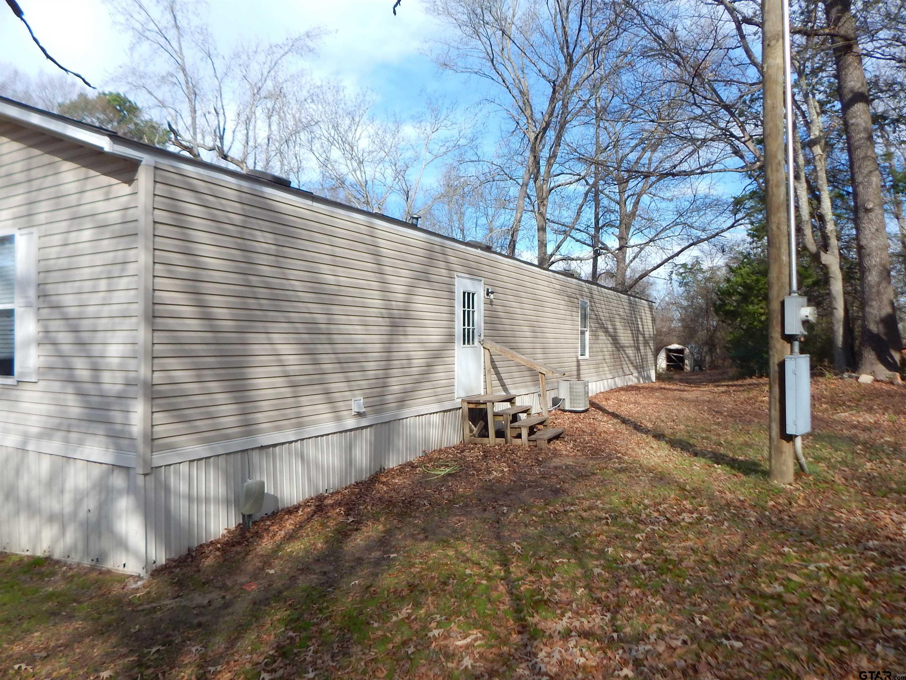 958 Boles Road Gilmer, TX 75645 - Photo 25 of 29 a backyard of a house with table and chairs